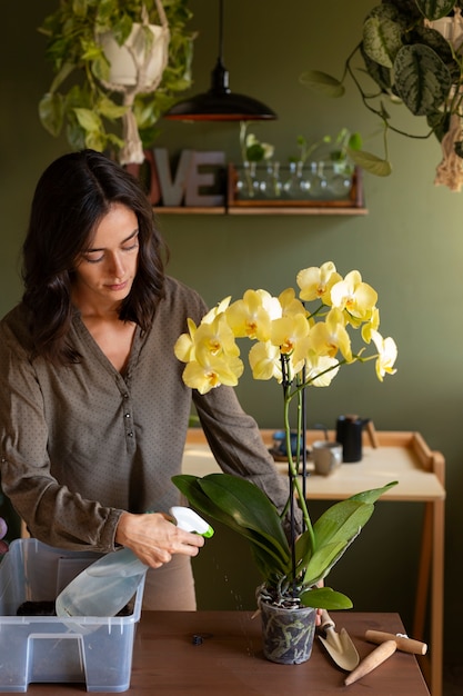 Kostenloses Foto eine frau schmückt ihr haus mit orchideen