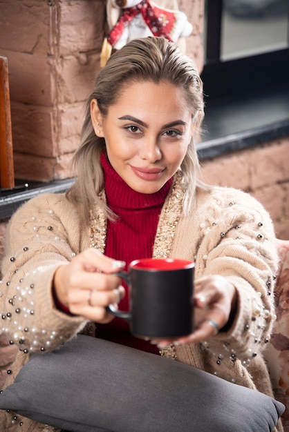 Eine Frau sitzt und bietet Kaffee an