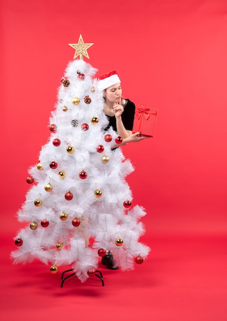 Eine Frau steht neben dem Weihnachtsbaum