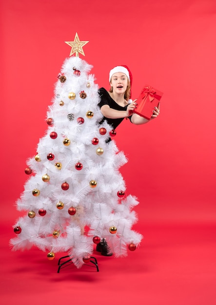 Eine Frau steht neben dem Weihnachtsbaum