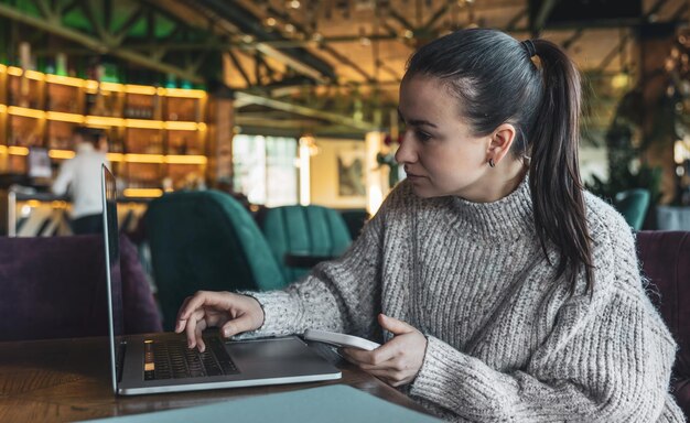 Eine Geschäftsfrau arbeitet mit einem Laptop in einem Café