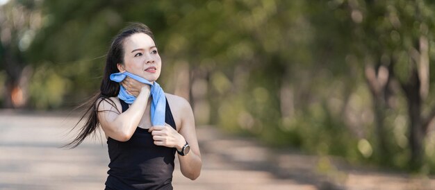 Eine gesunde, glückliche asiatische Läuferin in schwarzen Sportoutfits joggt