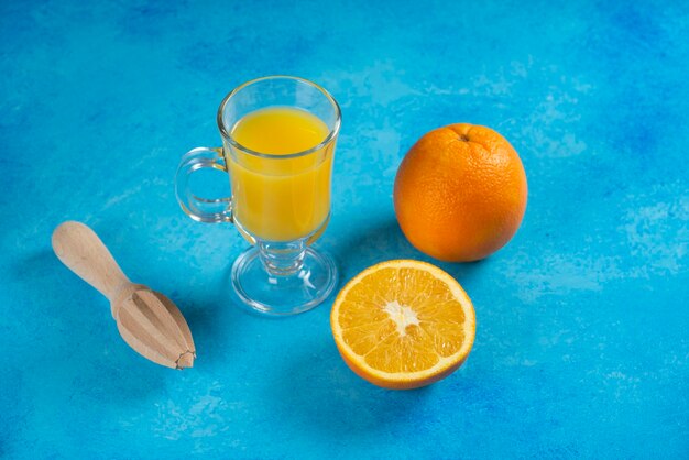 Eine Glasschale Orangensaft auf Blau.