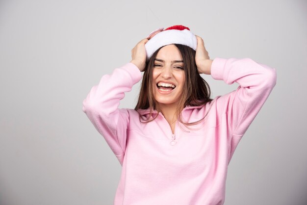 Eine glückliche Frau in der roten Hutaufstellung des Weihnachtsmannes.