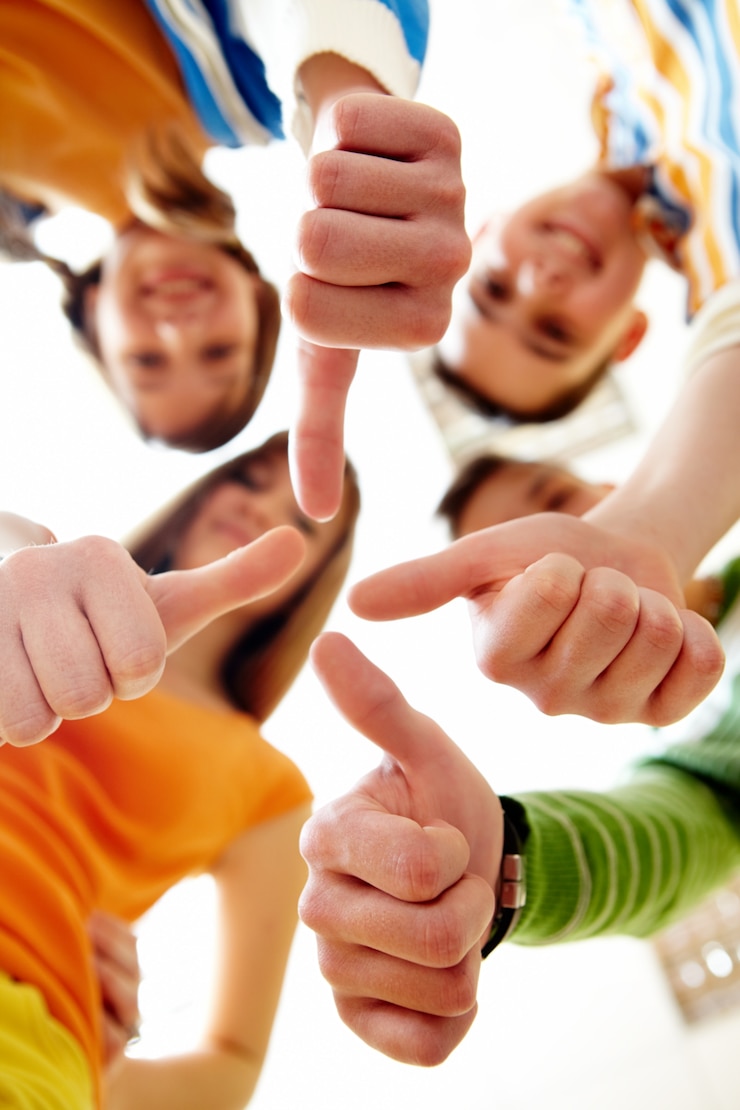 Kostenlose Foto eine glückliche gruppe von freunden mit den daumen hoch