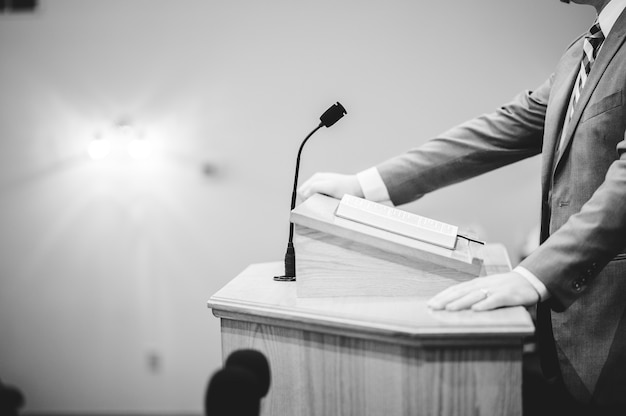 Kostenloses Foto eine graustufenaufnahme eines mannes, der auf dem podium spricht