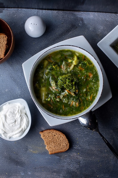 Kostenloses Foto eine grüne borsh-gemüsesuppe der draufsicht zusammen mit saurer sahne und brot