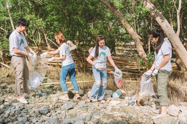 Eine Gruppe asiatischer, vielfältiger Menschen, die sich freiwillig für die Teamarbeit im Umweltschutz engagieren, helfen beim Sammeln von Plastik- und Schaummüll auf dem Parkgelände. Freiwilligenarbeit am Weltumwelttag