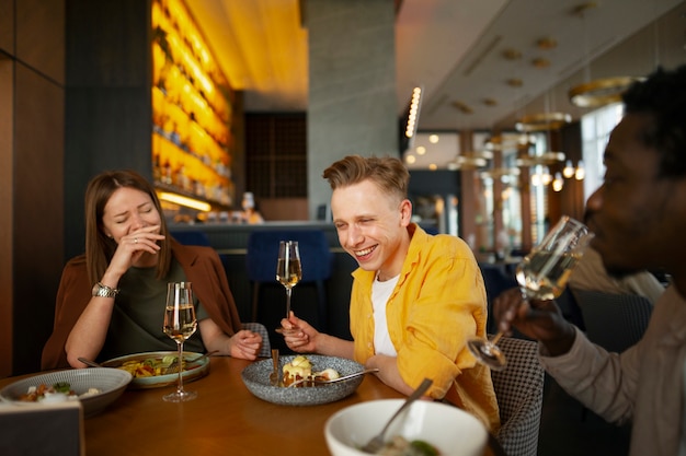 Kostenloses Foto eine gruppe von freunden isst gemeinsam im restaurant zu mittag