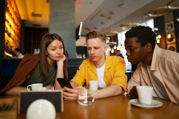 Eine Gruppe von Freunden schaut sich gemeinsam im Restaurant die Speisekarte an