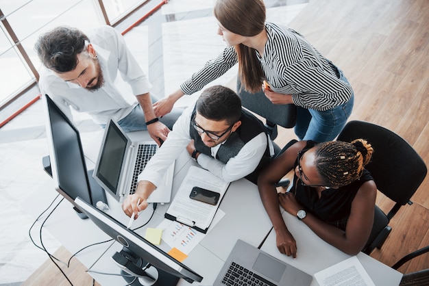 Eine Gruppe von multinationalen Beschäftigten, die im Büro arbeiten.