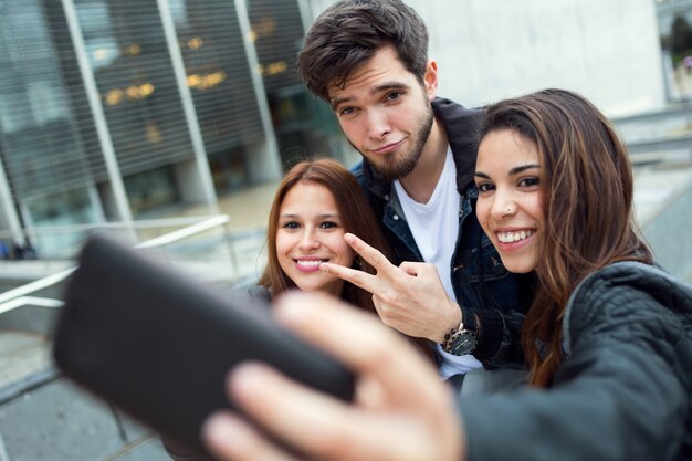 Eine Gruppe von Studenten, die Spaß mit Smartphones nach dem Unterricht haben.