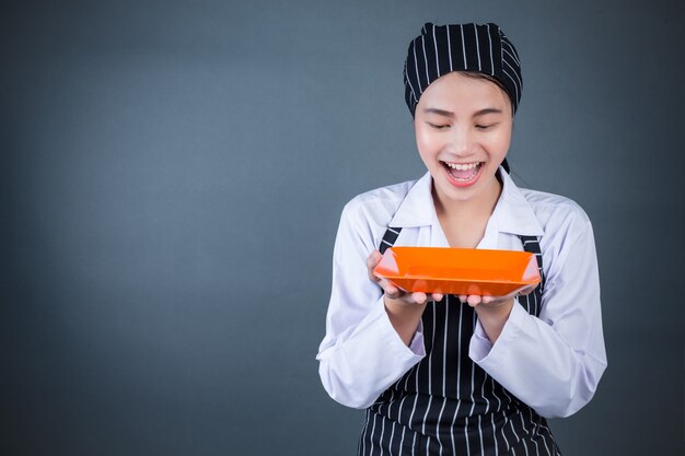 Eine Hausfrau, die eine leere Platte mit Lebensmittel hält