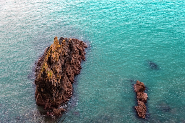 Eine hohe Winkelansicht von Felsen in einem Meer unter dem Sonnenlicht in Irland