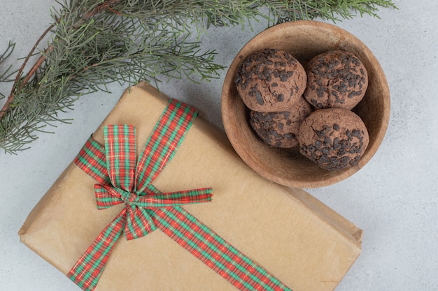 Eine Holzschale mit Schokoladenkeksen mit Weihnachtsgeschenk