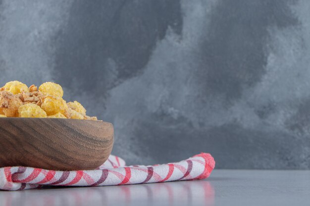 Eine Holzschüssel mit leckeren gesunden Cerealien auf einer Tischdecke