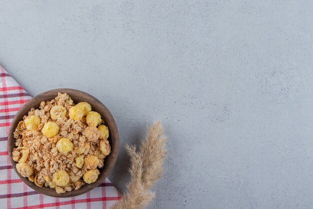 Eine Holzschüssel mit leckeren gesunden Cerealien auf einer Tischdecke