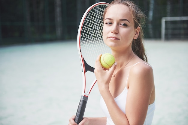 Eine hübsche Frau, die einen Sportbekleidungs-Tennisplatz auf dem Platz trägt.