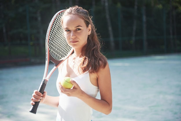 Kostenloses Foto eine hübsche frau, die einen sportbekleidungs-tennisplatz auf dem platz trägt.