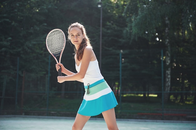 Eine hübsche Frau, die einen Sportbekleidungs-Tennisplatz auf dem Platz trägt.