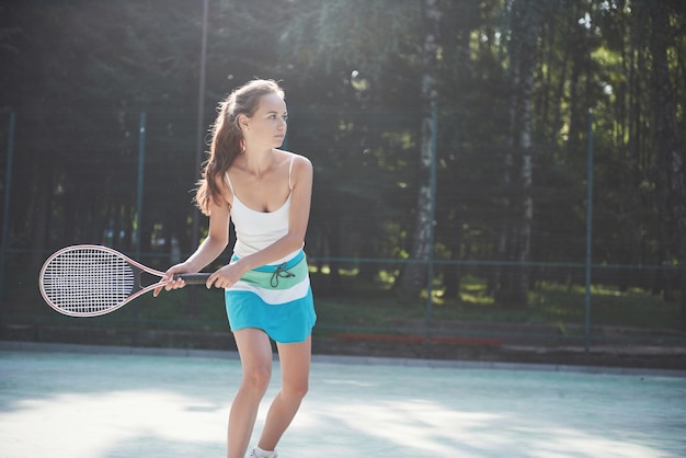 Eine hübsche Frau, die einen Sportbekleidungs-Tennisplatz auf dem Platz trägt.