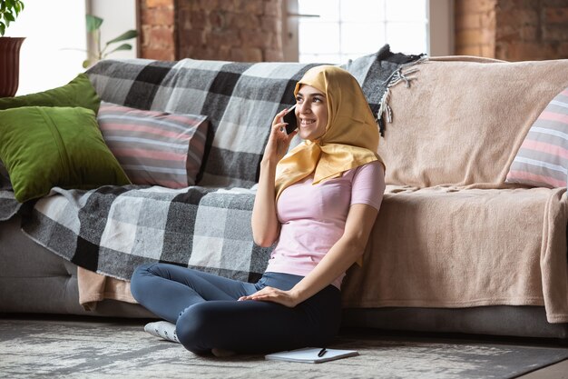 Eine hübsche junge muslimische Frau zu Hause während Quarantäne und Selbstisolierung