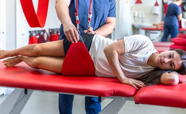 Eine junge Frau bei einem Arztbesuch bei einem Rehabilitologen