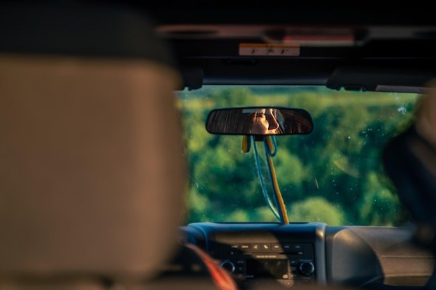 Kostenloses Foto eine junge frau, die einen roten geländewagen in der landschaft fährt, blickt auf reflexion
