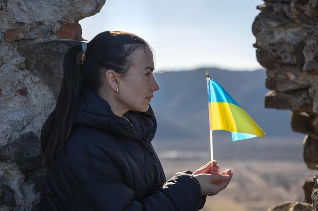 Eine junge Frau mit der Flagge der Ukraine in ihren Händen