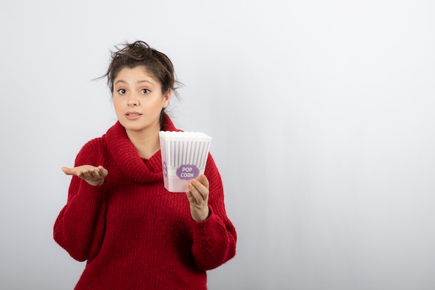 Eine junge Frau mit einem Eimer Popcorn.