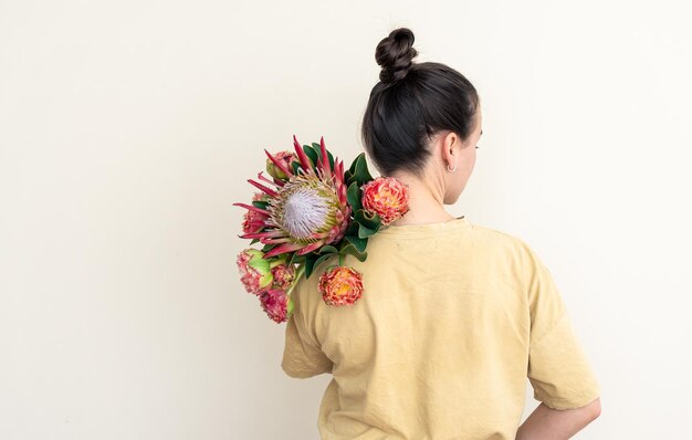 Eine junge Frau mit Protea-Blume auf weißem Hintergrund