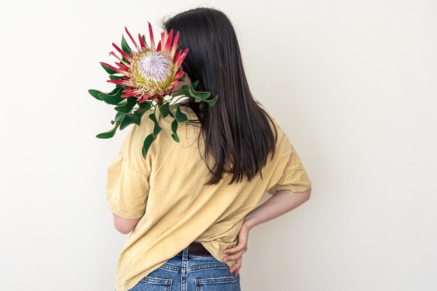 Eine junge Frau mit Protea-Blume auf weißem Hintergrund