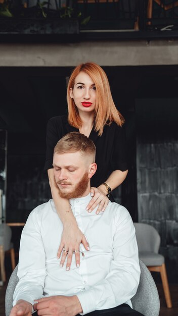 Eine junge Frau und ihr Freund posieren drinnen für die Kamera.