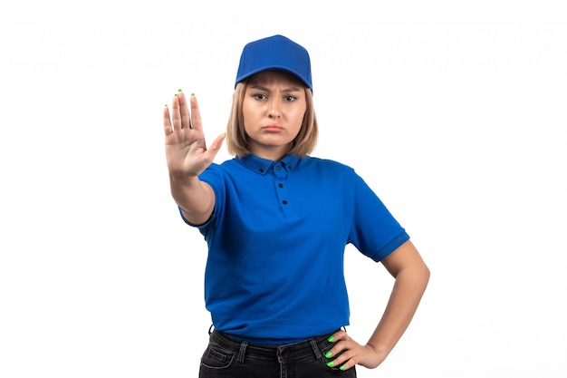Eine junge Kurierin der Vorderansicht in der blauen Uniform, die gerade aufstellt und Stoppschild zeigt