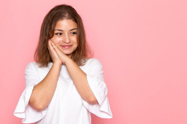 Eine junge schöne Frau der Vorderansicht im weißen Hemd mit dem glücklichen Ausdruck auf ihrem Gesicht, das aufwirft