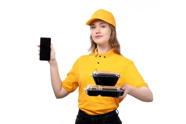 Eine junge weibliche Kurierarbeiterin der Vorderansicht des Lebensmittel-Lieferservices, die Smartphone und Futternäpfe auf Weiß hält