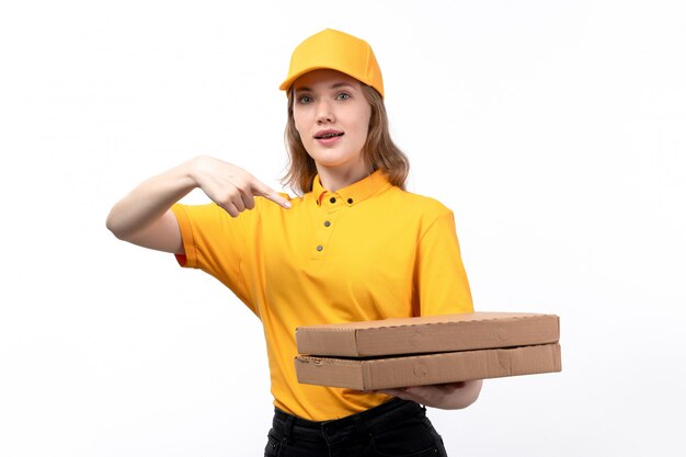 Eine junge weibliche Kurierfrau der Vorderansicht des Lebensmittellieferdienstes, der Pizzaschachteln hält, die auf Weiß lächeln