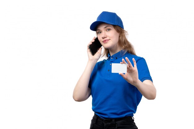 Eine junge weibliche Kurierfrau der Vorderansicht des Lebensmittellieferdienstes lächelnd, die weiße Karte hält und am Telefon auf Weiß spricht