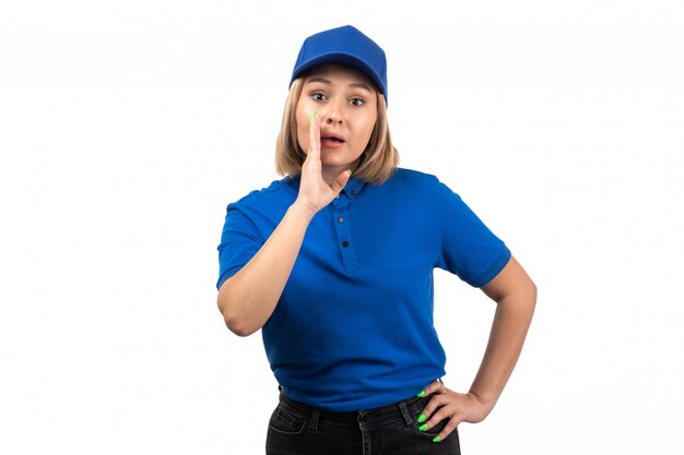 Eine junge weibliche Kurierin der Vorderansicht in der blauen Uniform, die gerade aufwirft und ruft