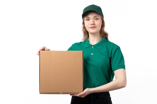 Eine junge weibliche Kurierin der Vorderansicht in der grünen Uniform lächelnd, die Paket mit Essen hält