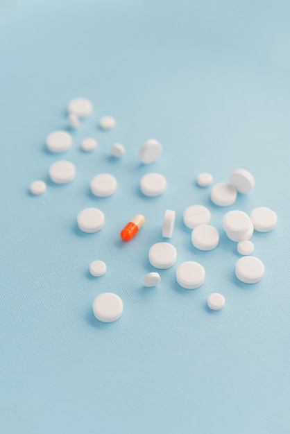 Eine Kapsel, umgeben von weißen Tabletten