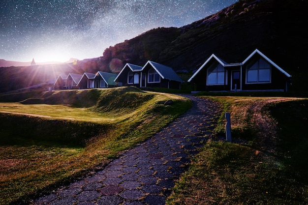 Eine kleine Holzkirche und Friedhof Hofskirkja Hof, Skaftafell Island. Szenischer Sonnenuntergang durch Baumkronen