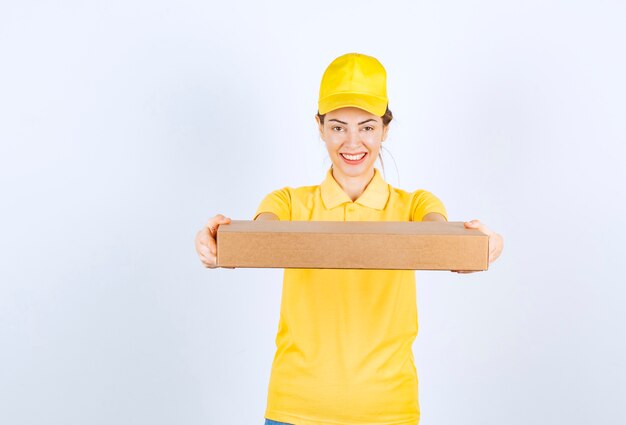 Eine Kurierin in gelber Uniform lieferte ein Papppaket an die richtige Adresse.