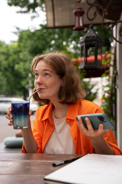 Eine mittelgroße Frau genießt einen blauen Matcha