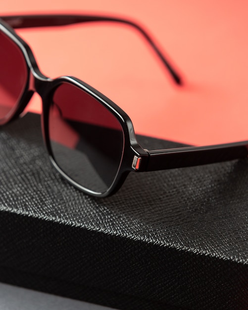 Eine moderne schwarze Sonnenbrille der Vorderansicht auf der rosa-dunklen