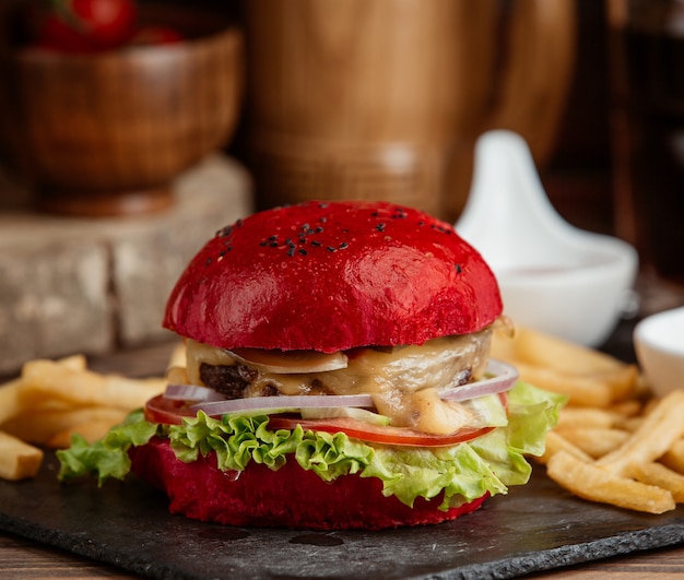 eine Nahaufnahme von rotem Burger mit Salat, Zwiebel, geschmolzenem Käse