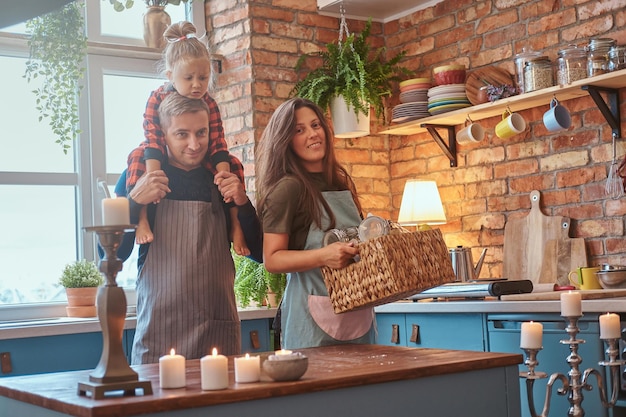 Eine nette kleine Familie steht zusammen in der Küche und plant etwas zu kochen.