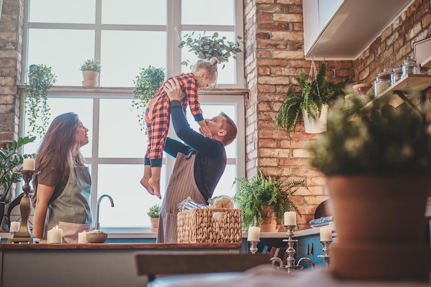 Eine nette kleine Familie steht zusammen in der Küche und plant etwas zu kochen.