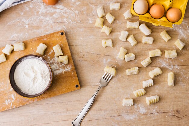 Eine obenliegende Ansicht der Gabel für die Zubereitung der frischen italienischen Teigwaren Gnocchi auf hölzernem Schreibtisch