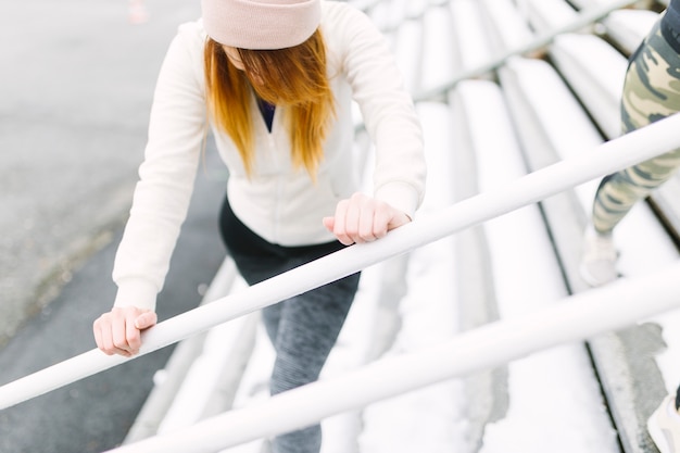 Eine obenliegende Ansicht der jungen Frau trainierend im Winter